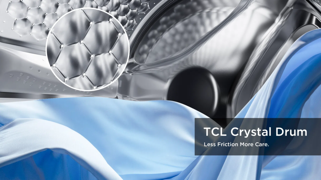 Close-up of a front-loading washing machine drum with a metallic, crystal-like texture and blue fabric flowing across the front.